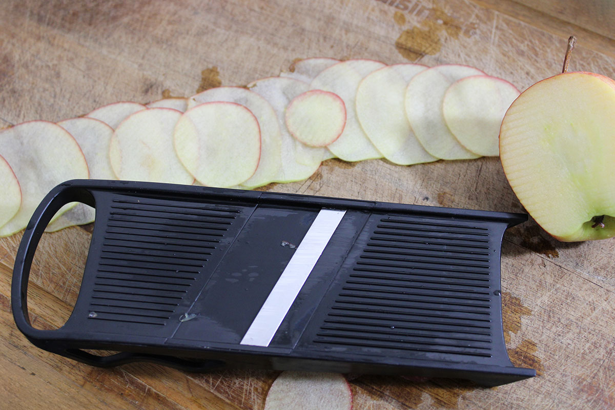 Mandoline sliced apple slices overlapping in a row.