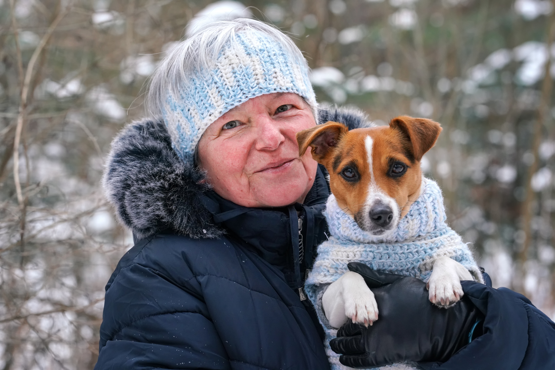 Woman and dog wearing matching crocheted sweater and ear warmer